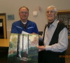 Les Stewart, left, with HWOA chair Bruce Keeling. Stewart won the Meade Helman painting donated by AWARE Simcoe