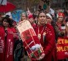 Casey Camp-Horinek of the Ponca Nation, Oklahoma presents a traditional cradleboard to the people of Paris during a march Dec. 12. The cradleboard represents future generations.. -IIndigenous Environmental Network photo